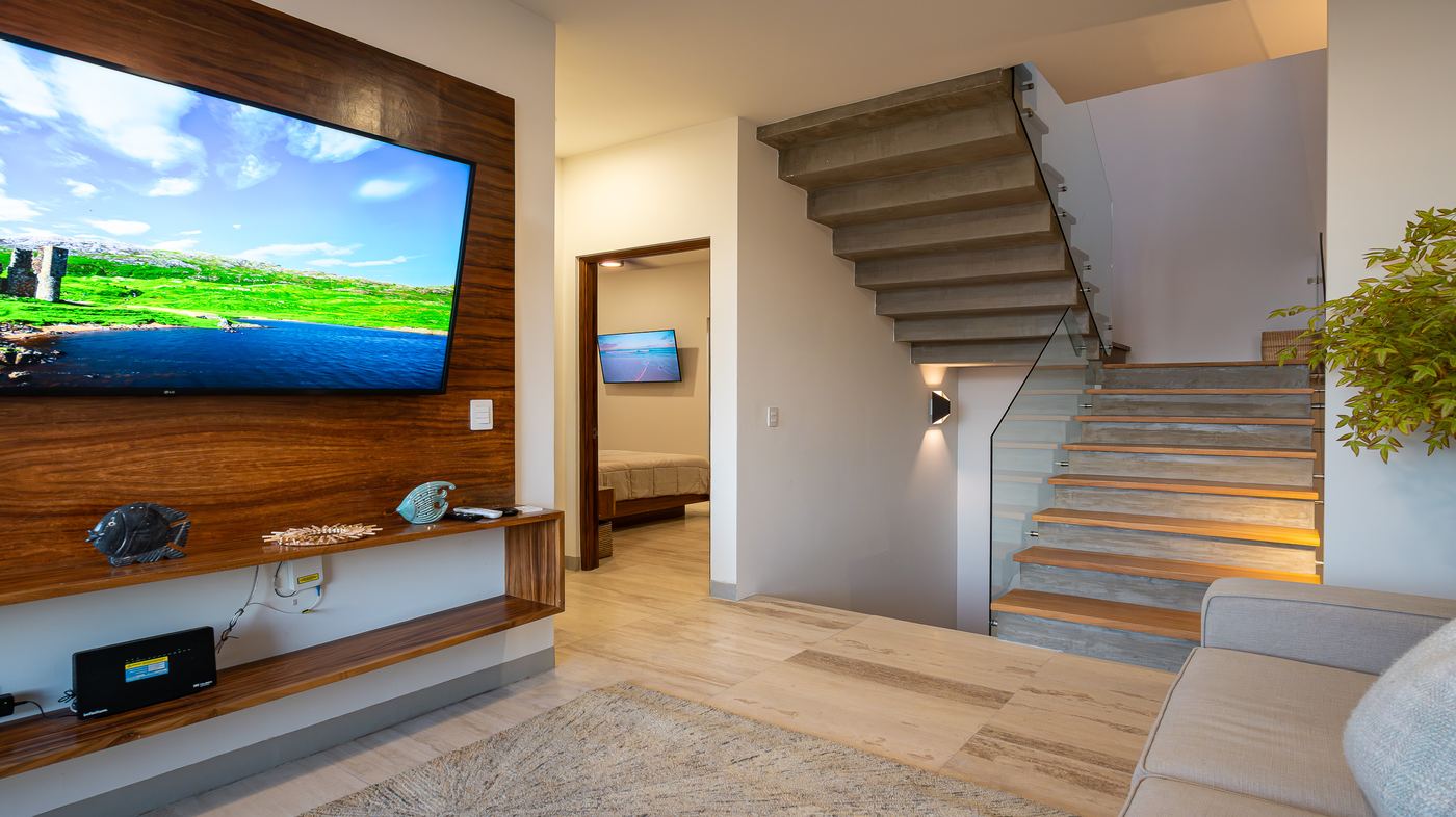 Antesala del segundo nivel con pantalla grande y salida al balcón